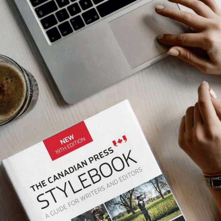 An overhead view of a laptop and a CP Stylebook.