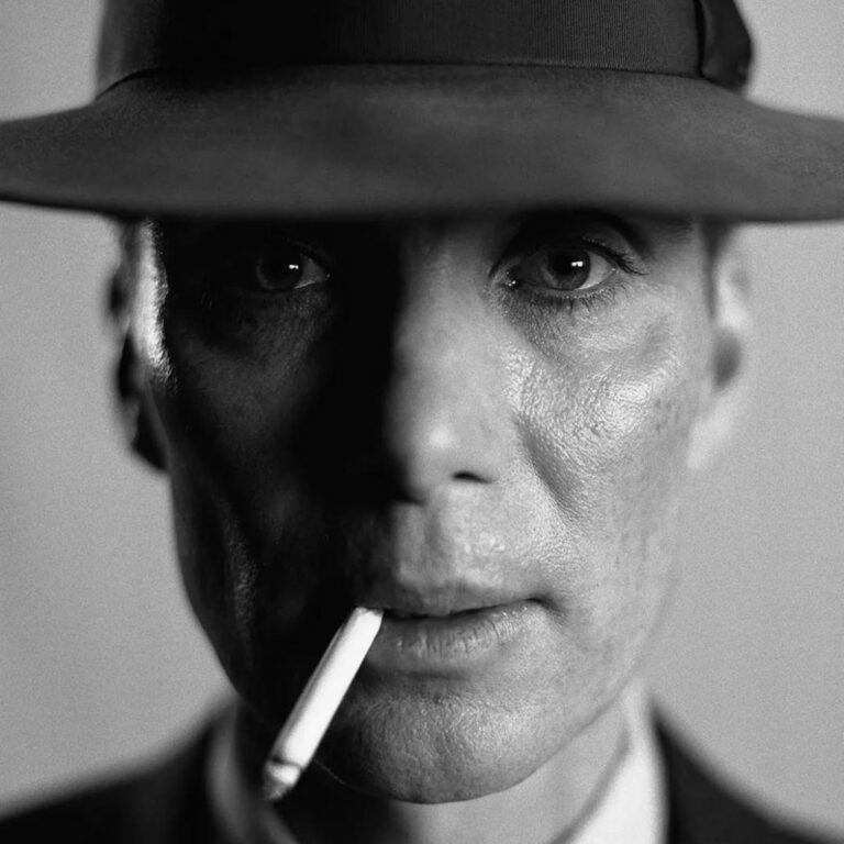 A scene from the Oppenheimer, where it's a close-up of the actor playing Oppenheimer wearing a hat and has a cigarette hanging from his lips.