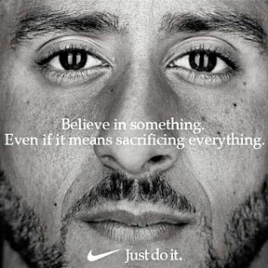 A close-up black and white photo of Colin Kaepernick's face with white text over top that reads, "Believe in something. Even if it means sacrificing everything." The Nike logo and slogan, "Just Do It" are at the bottom in white.