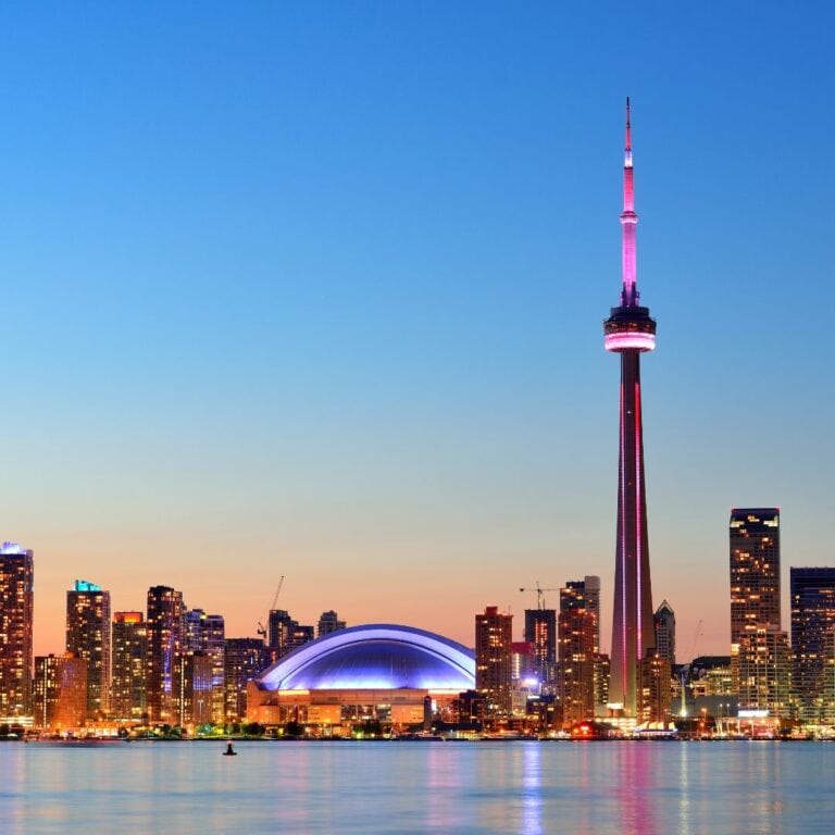 The Toronto skyline at dusk with the CN Tower in the foreground.
