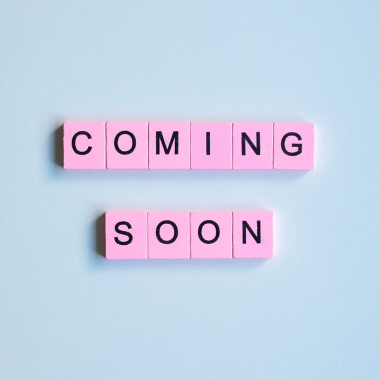 Pink Scrabble tiles spell out the words: coming soon. They sit on a light blue background.