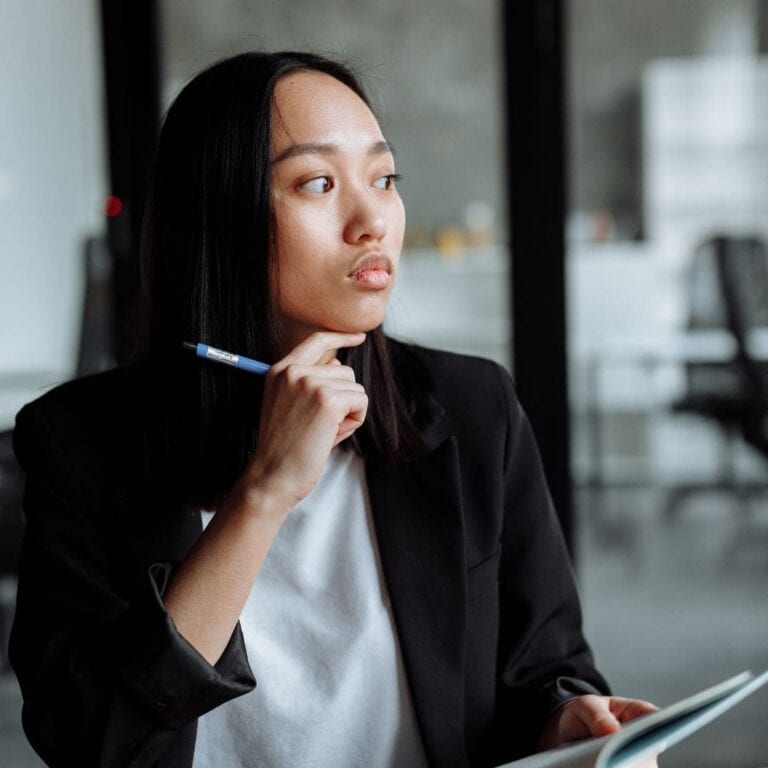 A person sitting at a table with a pen and paper