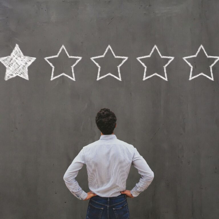 A person stands in front of a wall with a one-out-of-five-star rating drawn on it.